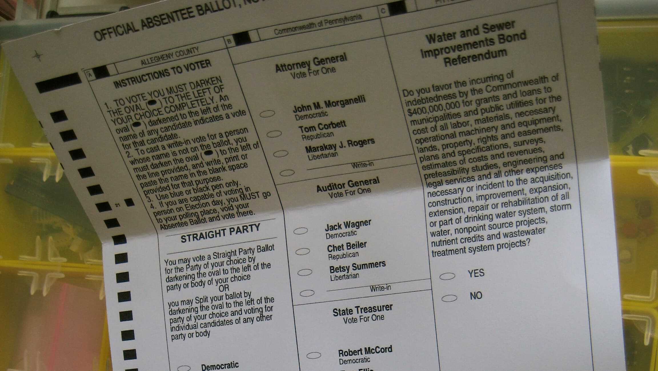 The top of an official absentee ballot sitting in a sorting tray