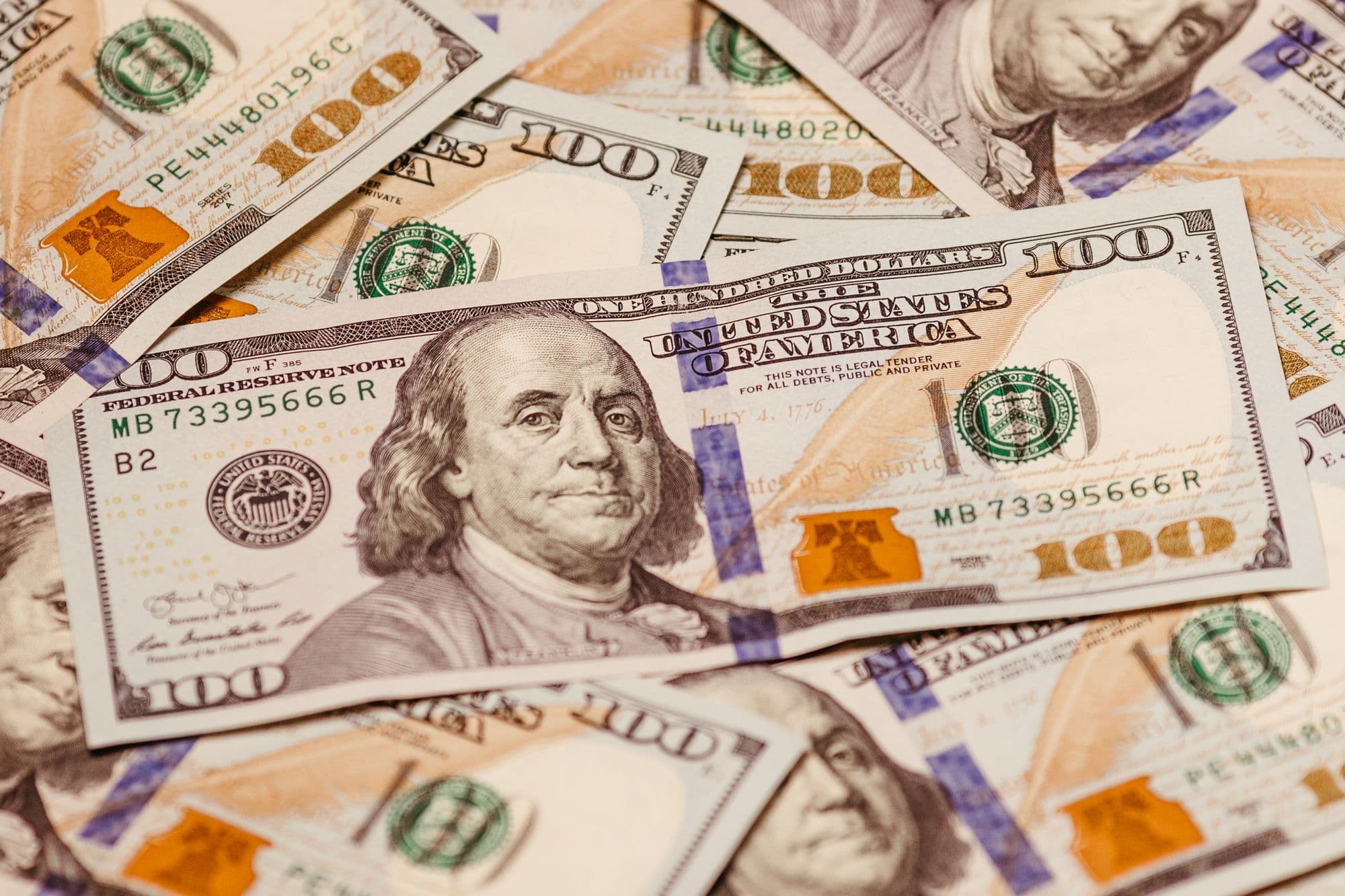 A close-up spread of US one hundred dollar bills