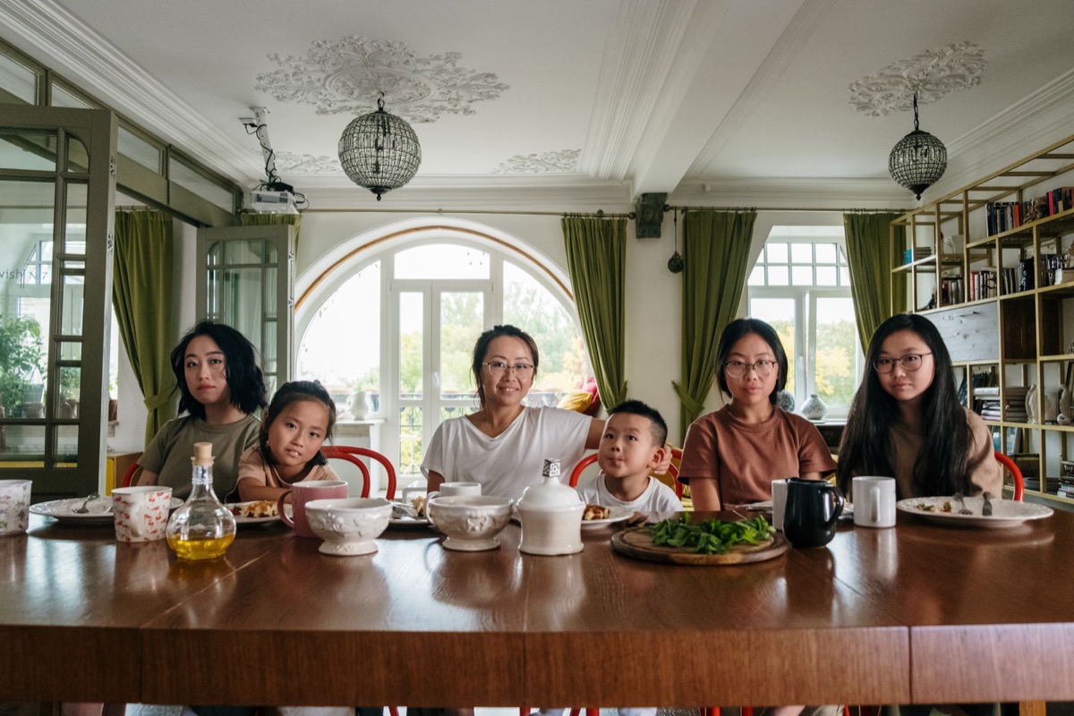 A mother and five children around the family dinner table at home
